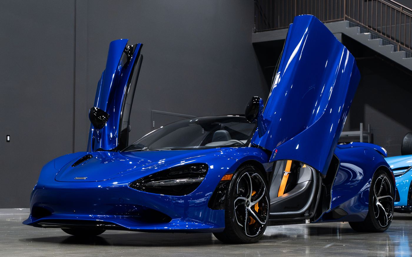 2024 McLaren 750S Spider in Aurora Blue, doors up on the showroom floor